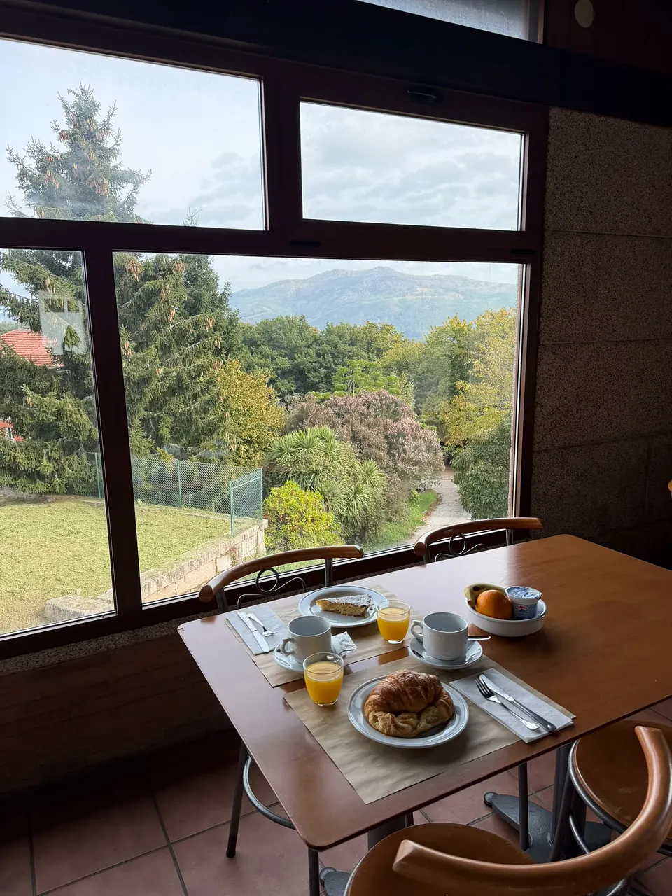 Desayuno servido junto al ventanal de El Bosque, con vistas al jardín y al monte